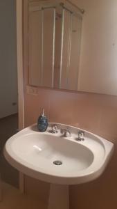 a white sink in a bathroom with a mirror at Villa Elisa in Punta Ala