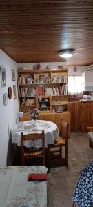 a dining room with a table and chairs and book shelves at Athina Country House in Kouramádes