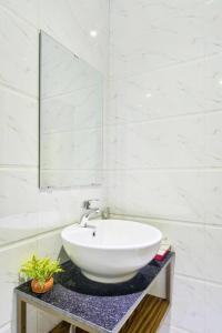 La salle de bains blanche est pourvue d'un lavabo et d'un miroir. dans l'établissement Annie Danang Hotel & Apartment, à Đà Nẵng
