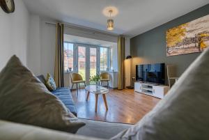 a living room with a blue couch and a tv at NEC Exhibitor Home, Stay near Birmingham Airport in Birmingham