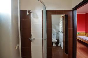 ソンバトヘイにあるKispipa Panzióのバスルーム(トイレ、ガラス張りのシャワードア付)