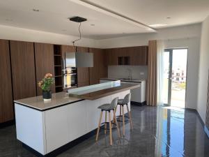 una cocina con encimera y taburetes. en Frank's 350 Sqm Churchill Penthouse, en San Ġwann