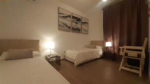 una camera con due letti e una sedia e due lampade di Villa Elisa a Punta Ala