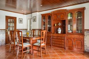 a dining room with a table and wooden cabinets at ALTIDO Superb house with garden and patio in Charneca