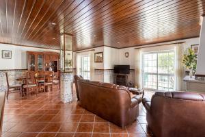 a living room with leather furniture and a dining room at ALTIDO Superb house with garden and patio in Charneca