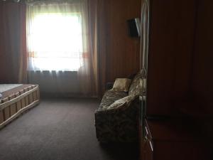 a bedroom with a couch in front of a window at Guest house Zatishniy dvir in Yaremche