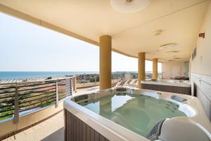 bañera de hidromasaje en un balcón con vistas al océano en Laguna Park Hotel 4Superior en Bibione