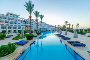 una piscina en un complejo con sillas y sombrillas en Siva Sharm Resort & SPA - Couples and Families Only, en Sharm El Sheikh