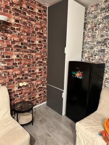 a living room with a brick wall and a black refrigerator at Venezia in Abruzzo in Archi