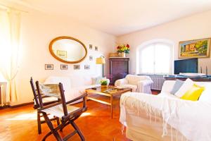 uma sala de estar com mobiliário branco e um espelho em Villa Stefania con Piscina em Magazzini