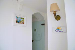 un corridoio con una porta e una lampada su un muro di Villa Mimosa ad Anacapri