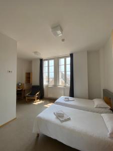 a bedroom with two beds and a desk and window at Hotel Saint Louis Beaulieu - Bordeaux in Bordeaux
