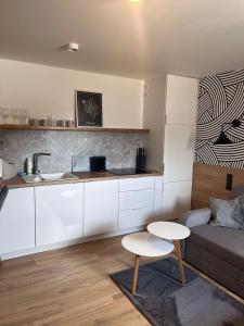 a kitchen and a living room with a couch and a table at Apartamenty Skórzewo in Skórzewo