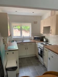 a kitchen with white cabinets and a sink at Family Bungalow sleeps 4 in Wellington