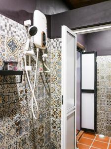 a bathroom with a shower with a blow dryer on the wall at Carnarvon Antique Loft in George Town