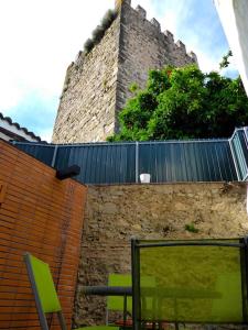 una pared de ladrillo con 2 sillas y un castillo en Casa da Torre by Portus Alacer en Portalegre