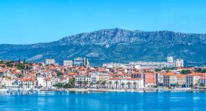 a city on the water with mountains in the background at Split Apartments 1-2 in Split