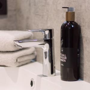 a black bottle of soap next to a bathroom sink at Vakantiedorp Marinapark in Middelkerke