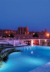 a swimming pool at night with a city in the background at Movenpick MS Sunray Nile Cruise 4 / 7 Nights Each Thursday From Luxor - 3 Nights Each Monday From Aswan in Luxor