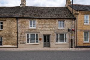 an old brick building with white windows and a door at Stylish central 6 bedroom converted Granary in Stamford