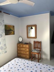 1 dormitorio con tocador, espejo y silla en Pis ampli i còmode a 5 min de l’Escala, en Bellcaire dʼEmpordà