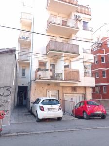 Zvezdara的住宿－NMD Apartments，两辆汽车停在大楼前