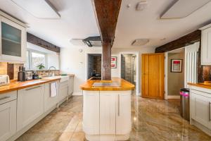 a kitchen with white cabinets and a large island at Stylish central 6 bedroom converted Granary in Stamford