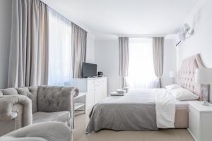 um quarto branco com uma cama e uma cadeira em Fryderyk em Krynica Morska