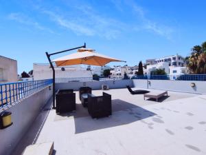 a patio with an umbrella and benches on a roof at Appartement richement meublé a Sidi Bou Said in Sidi Bou Saïd