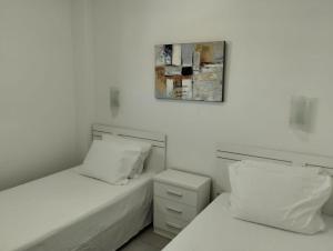 una camera con due letti e una foto a parete di PLAYA DEL INGLES-MASPALOMAS a Playa del Ingles