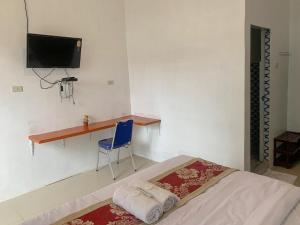 Schlafzimmer mit einem Bett, einem Schreibtisch und einem Stuhl in der Unterkunft RedDoorz at Agave Hotel Pematangsiantar in Pematangsiantar
