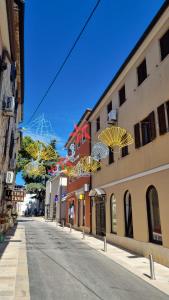 eine leere Straße mit Sonnenschirmen von Gebäuden in der Unterkunft Old Harbour in Novigrad Istria