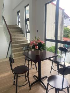 a table and chairs with a vase of flowers on it at Hana's Homestay Hue in Thôn Lại Thê