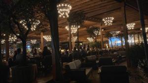 un restaurante con gente sentada en las mesas por la noche en Mamaia Beach Condos 2, en Năvodari