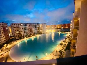 a large swimming pool in a city at night at Sia Lagoon 2 BR Porto Golf Marina Apartment with Garden Families only in El Alamein