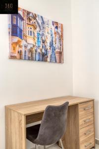 een bureau met een stoel en een schilderij aan de muur bij Stylish & Modern 1 BR Duplex APT in St Julians by 360 Estates in St Julian's