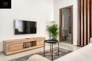 een woonkamer met een tv op een houten dressoir bij Stylish & Modern 1 BR Duplex APT in St Julians by 360 Estates in St Julian's