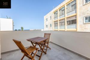 een terras met twee stoelen en een tafel op een balkon bij Stylish & Modern 1 BR Duplex APT in St Julians by 360 Estates in St Julian's +28 foto's