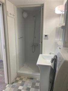 un bagno bianco con doccia e lavandino di COPO YONEGAHAMA l 米が浜通 a Kusugaurachō