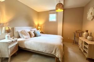 - une chambre avec un grand lit blanc et une fenêtre dans l'établissement maison aux Baux de Provence, aux Baux-de-Provence