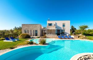 eine Villa mit einem Pool vor einem Haus in der Unterkunft Villa Flavia in Polignano a Mare