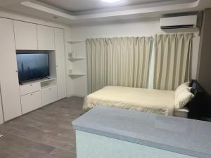 a small room with a bed and a television at COPO YONEGAHAMA l 米が浜通 in Kusugaurachō