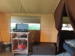 a room with a tent with a stove and a table at Camping Onlycamp Domelin in Beaufort