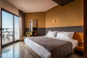 a hotel room with a bed and a balcony at Sea Life Nahariya BY Jacob Hotels in Nahariyya