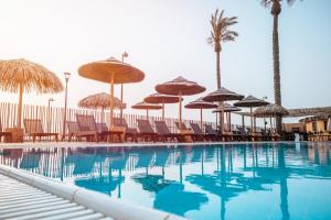 a swimming pool with chairs and umbrellas at Jacob Sea Life Nahariya in Nahariyya +56 photos