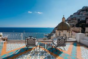 a balcony with two chairs and a view of the ocean at Villa Petite Syrene by Elite Villas in Positano