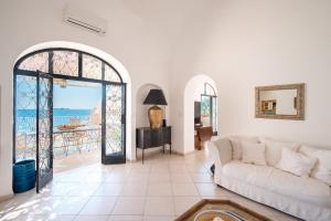 a living room with a couch and a view of the ocean at Villa Petite Syrene by Elite Villas in Positano