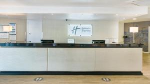 リーにあるHoliday Inn Express Leigh - Sports Village, an IHG Hotelのロビー(建物内の大型カウンター付)