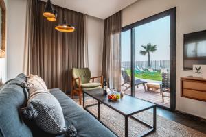 a living room with a couch and a table at Sea Life Nahariya BY Jacob Hotels in Nahariyya
