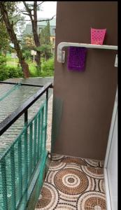Pokój dysponuje balkonem z fioletowym ręcznikiem i podłogą wyłożoną kafelkami. w obiekcie 1st line apartment in Kobuleti w Kobuleti